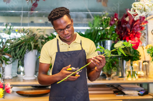 young african entrepreneur making a bouquet of flowers photo