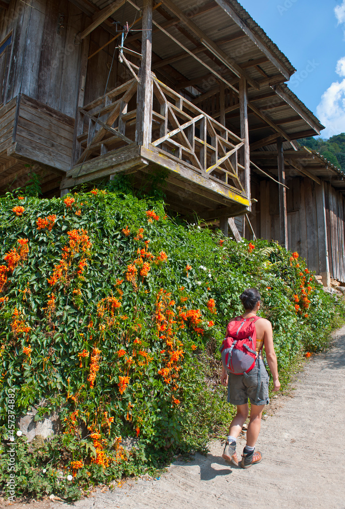 Woman walking through small village in northern Thailand Woman walking through small village in northern Thailand
