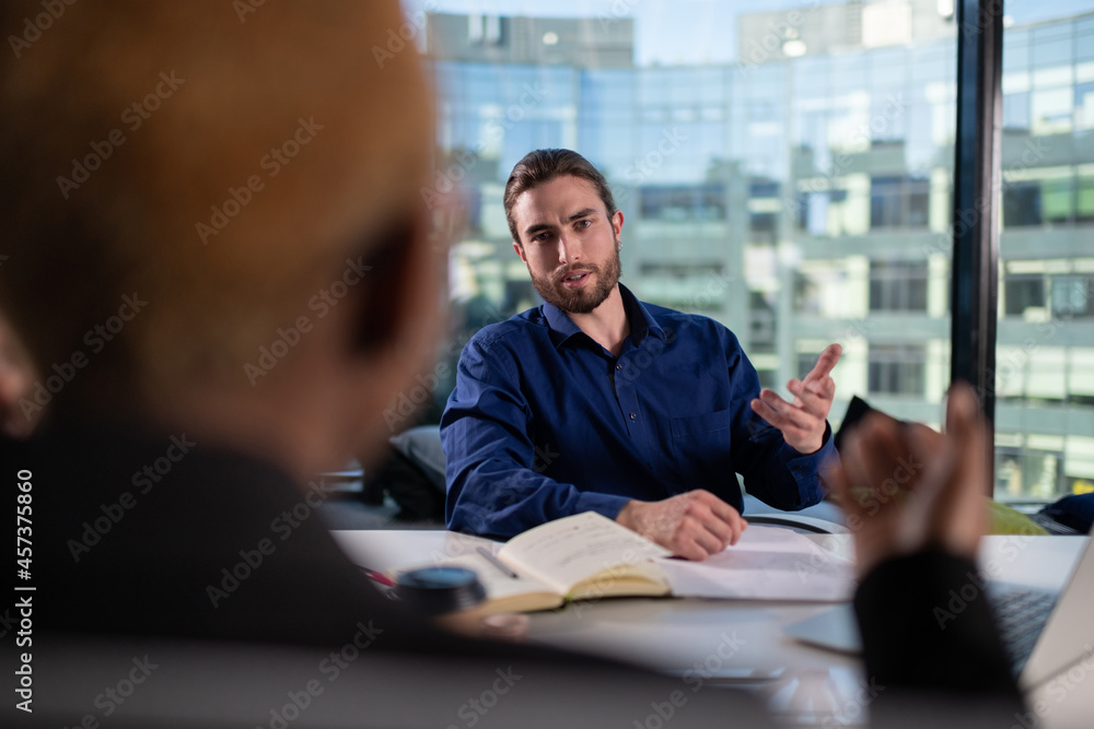Bearded businessman discussing work with colleague Bearded businessman discussing work with colleague