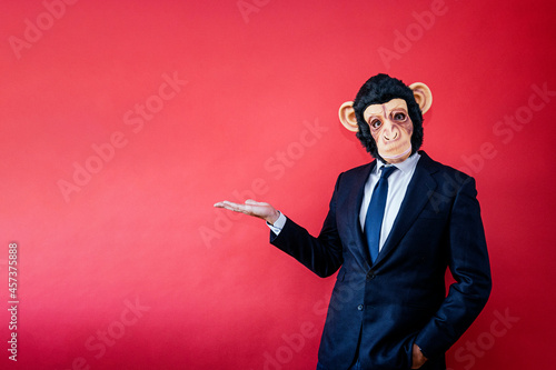 Canvas Print Businessman with monkey mask pointing to the side with hand