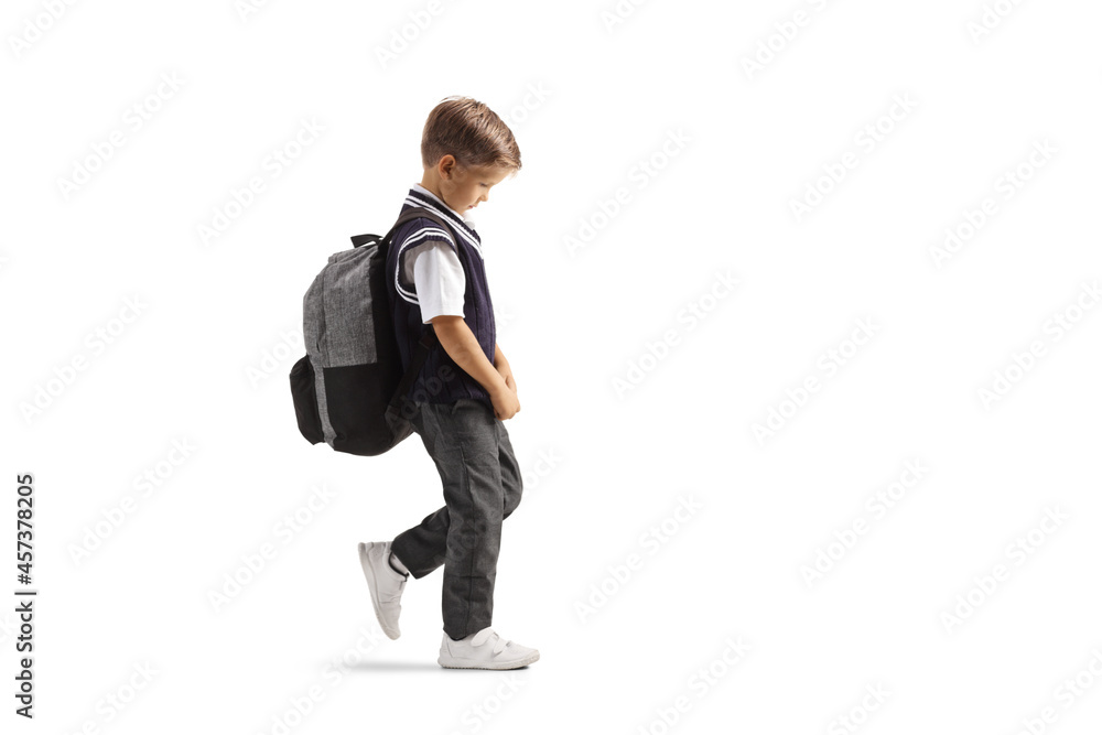 Full length profile shot of a boy in a school uniform walking sad Full length profile shot of a boy in a school uniform walking sad