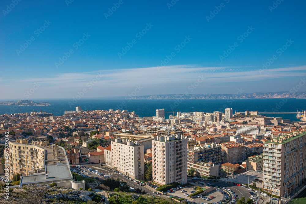 Panoramic bird view over modern and old center, port and suburbs in Marseille, France, at sundown and blue sky.
