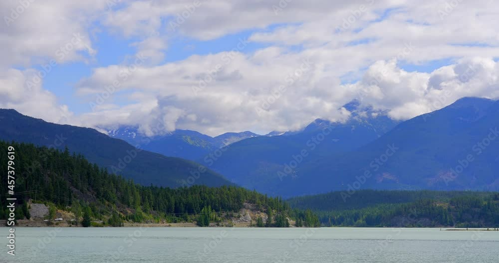 Establishing shot of lake with white clouds in Vancouver, Canada, North America. Day time on July 2021. Still camera view. ProRes 422 HQ. Establishing shot of lake with white clouds in Vancouver, Canada, North America. Day time on July 2021. Still camera view. ProRes 422 HQ.