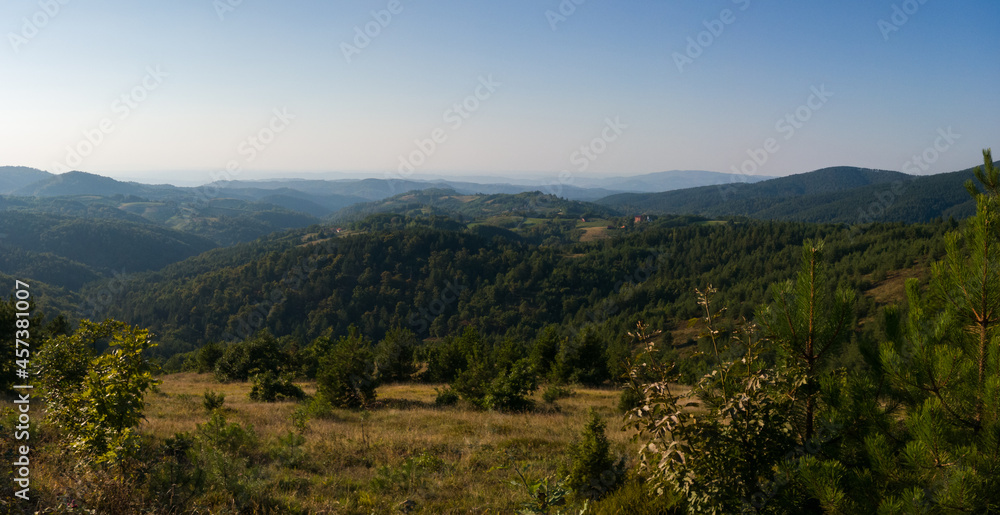 View of the slopes of the mountain Ozren, a hilly landscape with haze at horizon and mountain layers during sunny day
