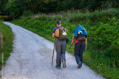 Young couple on pilgrimage to Santiago de Compostela with their backpacks. © Luis