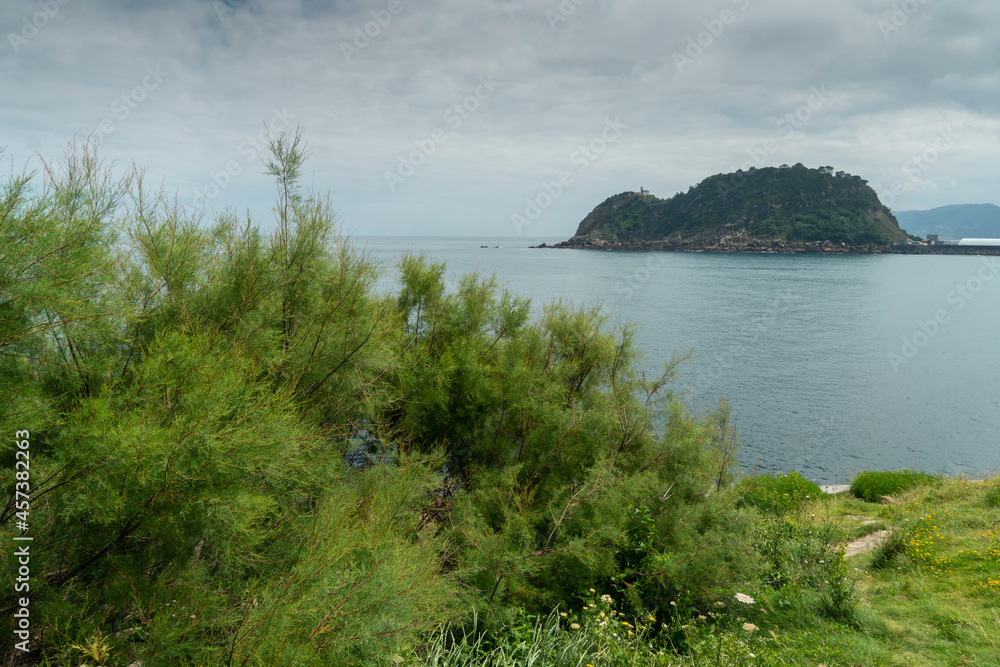  A white lighthouse on the mountain a blue sky day in summer in Guetaria, Basque Country, Spain