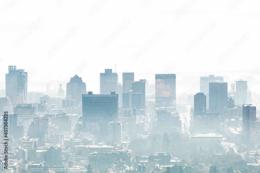 General view of cityscape with multiple modern buildings and skyscrapers in the foggy morning