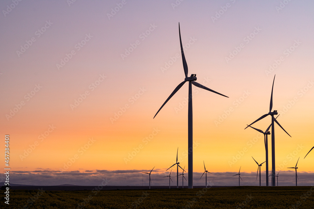 General view of wind turbines in countryside landscape during sunset General view of wind turbines in countryside landscape during sunset