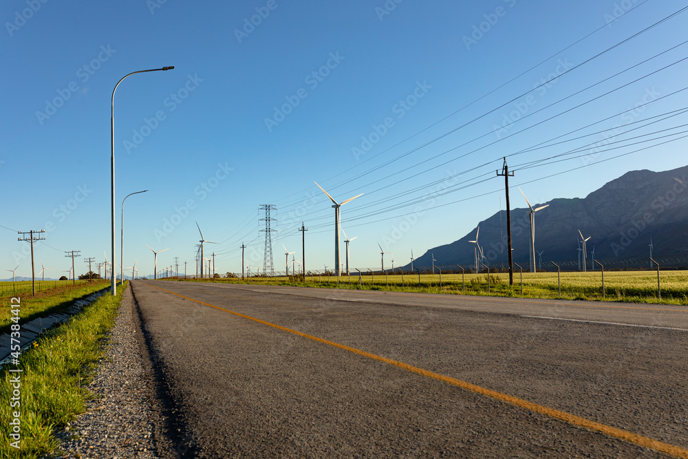 General view of wind turbines in countryside landscape with cloudless sky