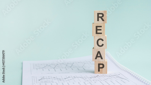 word recap with wood building blocks, light gray background photo