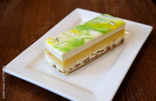 Slice of lemon cake on a square white plate in a cafe