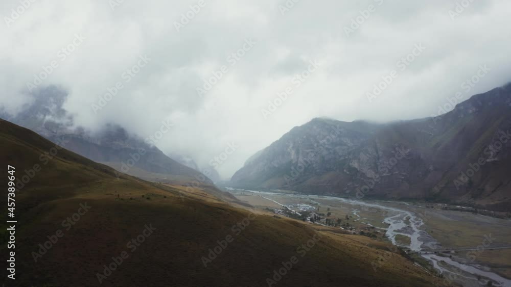 Beautiful view from quadcopter of a mountain valley, with rocky peaks in clouds Beautiful view from quadcopter of a mountain valley, with rocky peaks in clouds