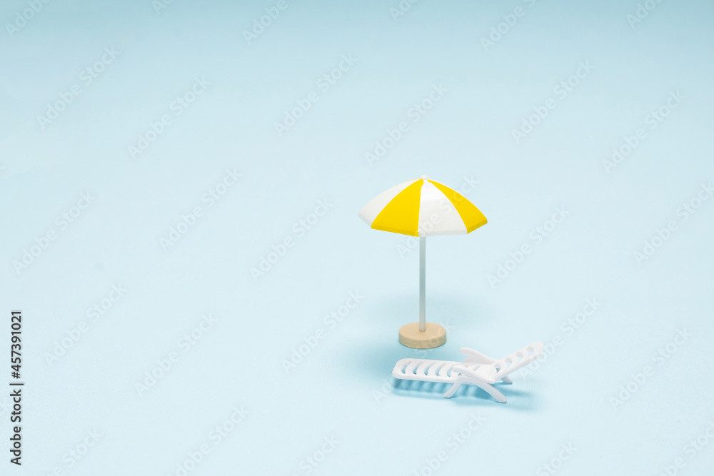 Travel concept. Sun lounger, yellow umbrella on a blue background.