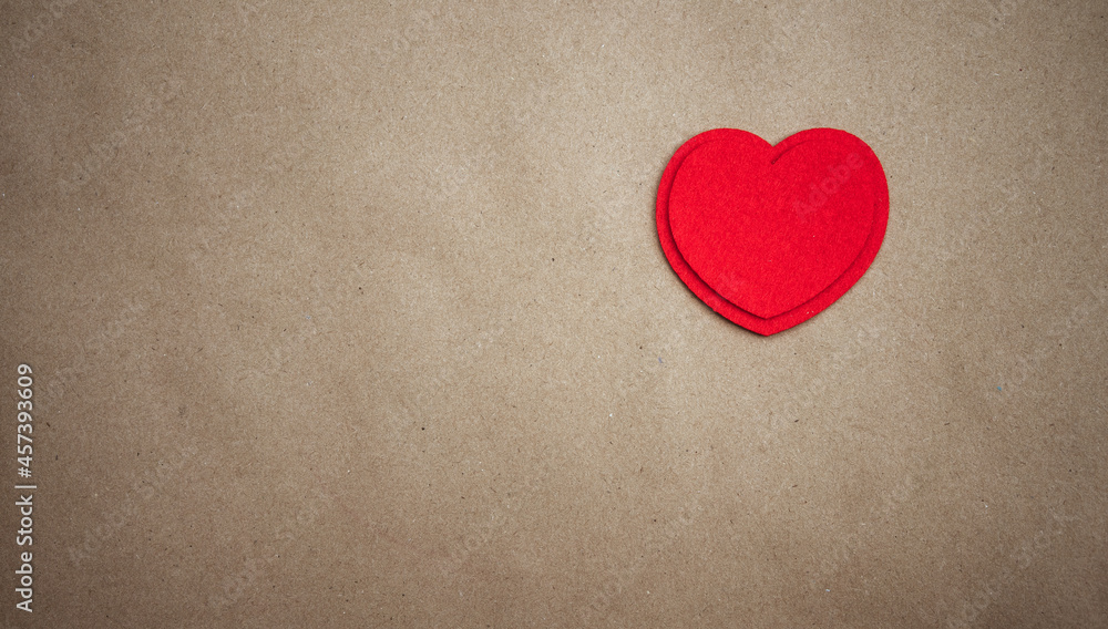Obraz premium Red heart made of textile fabric on a clean paper background.Texture for a greeting card with a declaration of love.