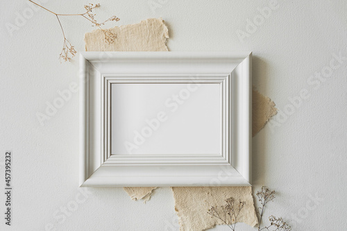 A horizontal photo frame surrounded by vintage letters lies on a white table.
