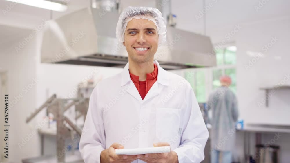 Portrait of food production technician or industry quality control expert looking at camera and smiling at cheese manufacturing factory. Male wearing white coat and disposable cap and holding notepad Portrait of food production technician or industry quality control expert looking at camera and smiling at cheese manufacturing factory. Male wearing white coat and disposable cap and holding notepad