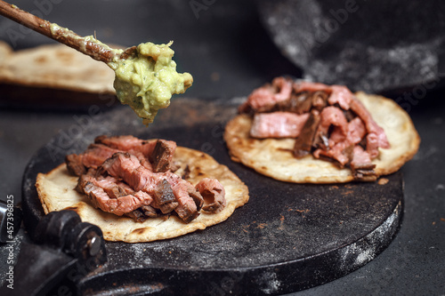 Fototapeta Naklejka Na Ścianę i Meble -  Process of cooking tacos with grilled flank beef steak with handmade guacamole