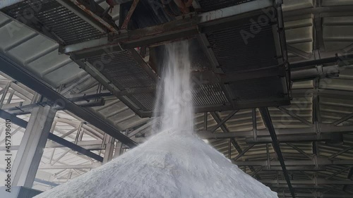 Ammonium sulfate powder pour in a pile inside a warehouse of chemical plant. Mineral organic fertilizers for agriculture industry.