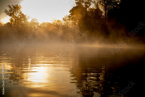 Sunrise canoe ride on foggy river. photo