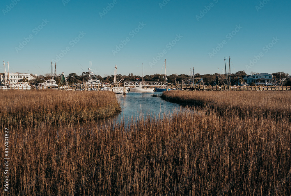 water marsh view with boats and boardwalk with sunny sky water marsh view with boats and boardwalk with sunny sky