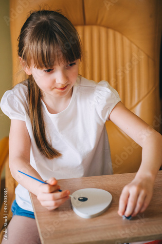 The girl paints an egg