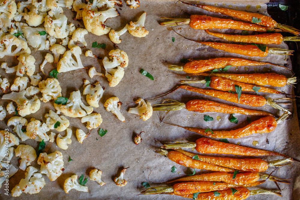 close-up of roasted carrots and cauliflower on parchment paper