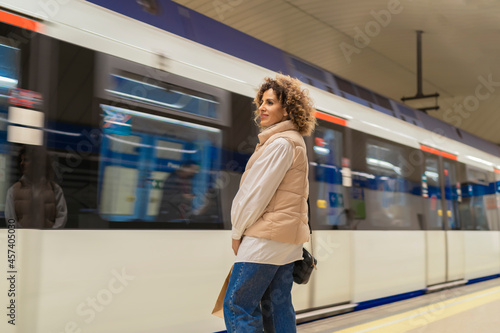 young woman waiting for the subway after shopping
