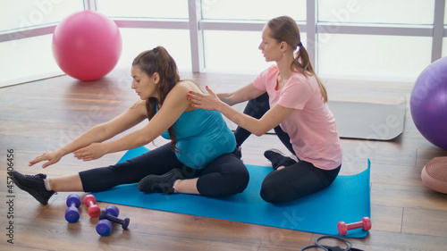 Pregnant Woman Goes in for Sports in the Gym. Personal Fitness Trainer Helps you with Exercise for Pregnant Women. Preparing the Body for Childbirth. Pregnancy, Sport and Health Concept.