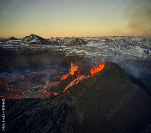 Scenic view of volcano erupting at sunset
