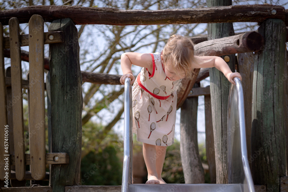 Obraz premium Young girl on the top of a slide watching down