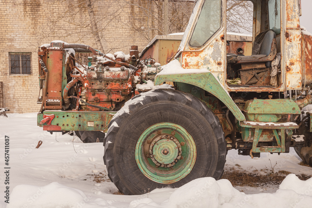 old rusty abandoned tractors in snowy winter