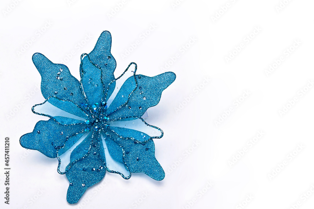 Fototapeta premium Cyan blue fabric and sequin poinsettia Christmas craft with space for text, minimal concept