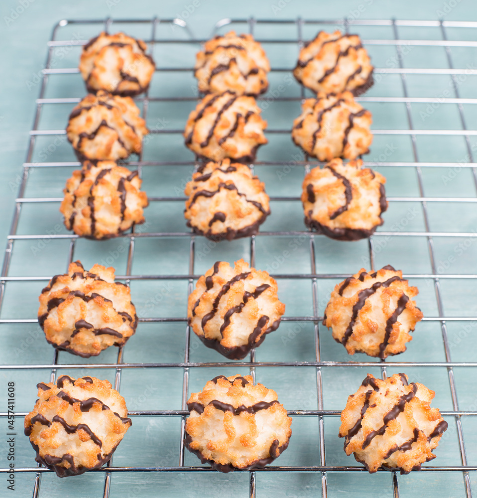 Coconut macaroons on a textured blue background, baking for christmas, cookies with chocolate and cocos Coconut macaroons on a textured blue background, baking for christmas, cookies with chocolate and cocos