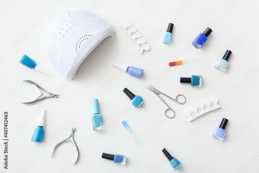 Set of tools for manicure and nail polishes on white background