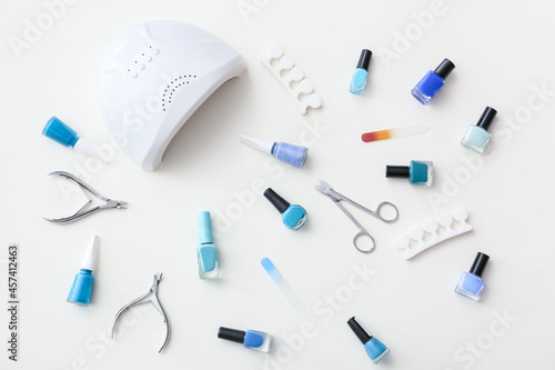 Set of tools for manicure and nail polishes on white background