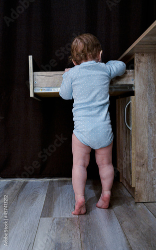 baby girl searching something in drawer photo