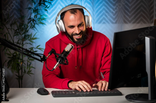 Content creator with headphones and microphone streaming a program online on the internet. Podcast presenter broadcasting on-air program. Content recording for internet program.