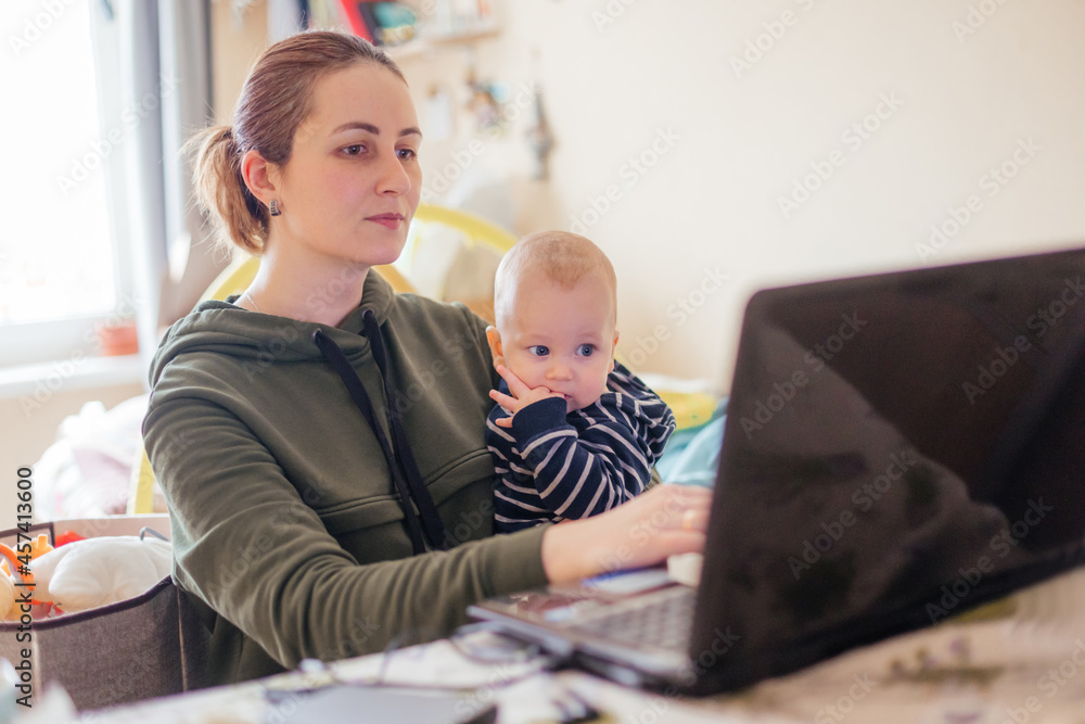 Young mother working from home together with her baby Young mother working from home together with her baby