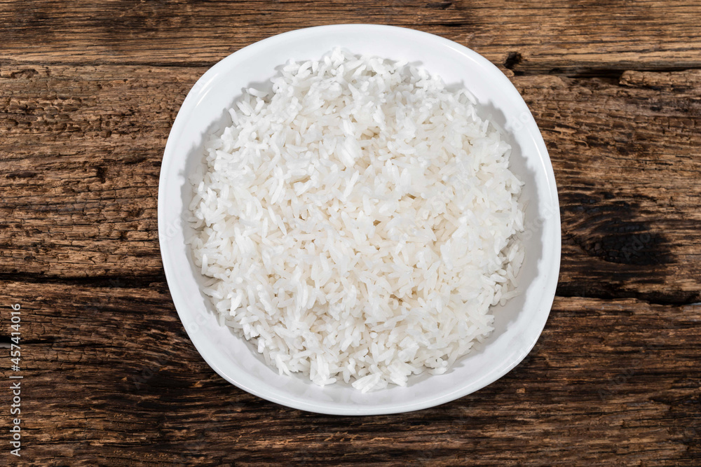 Rice in bowl isolated on wood Rice in bowl isolated on wood