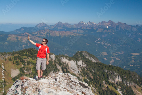 Man looks for phone connection while hiking in the mountains. photo