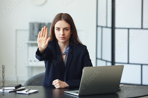 Young woman showing STOP ge...