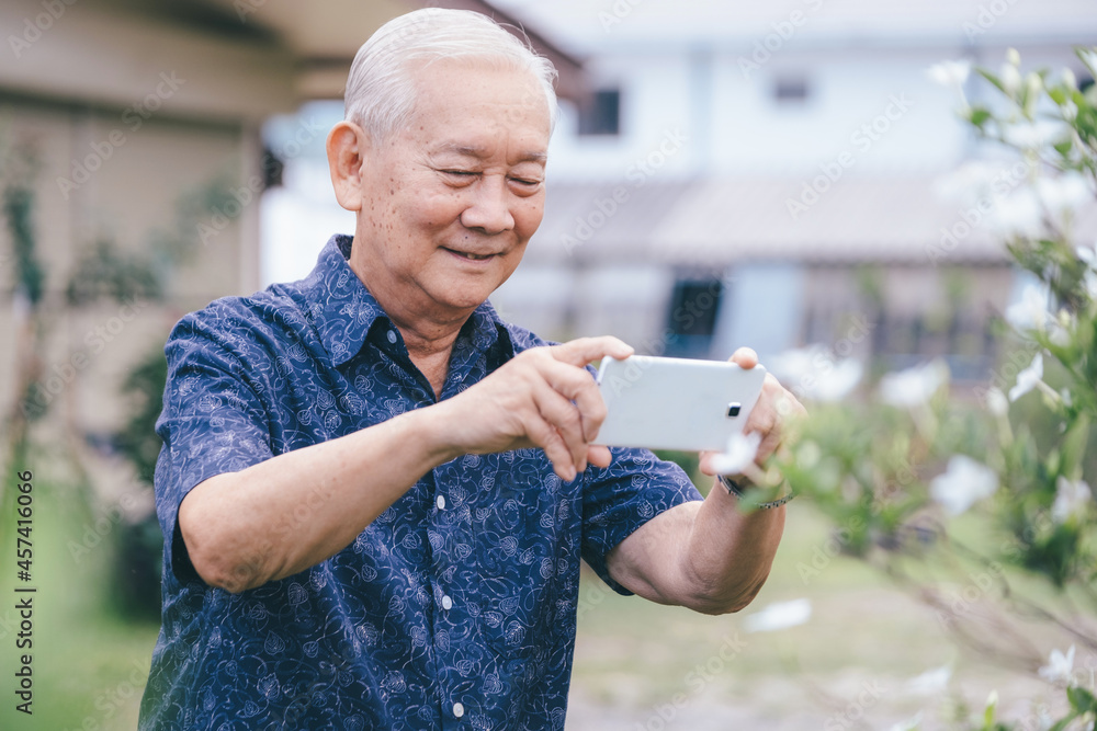 Happy asian senior man taking a picture with mobile phone. Happy asian senior man taking a picture with mobile phone.