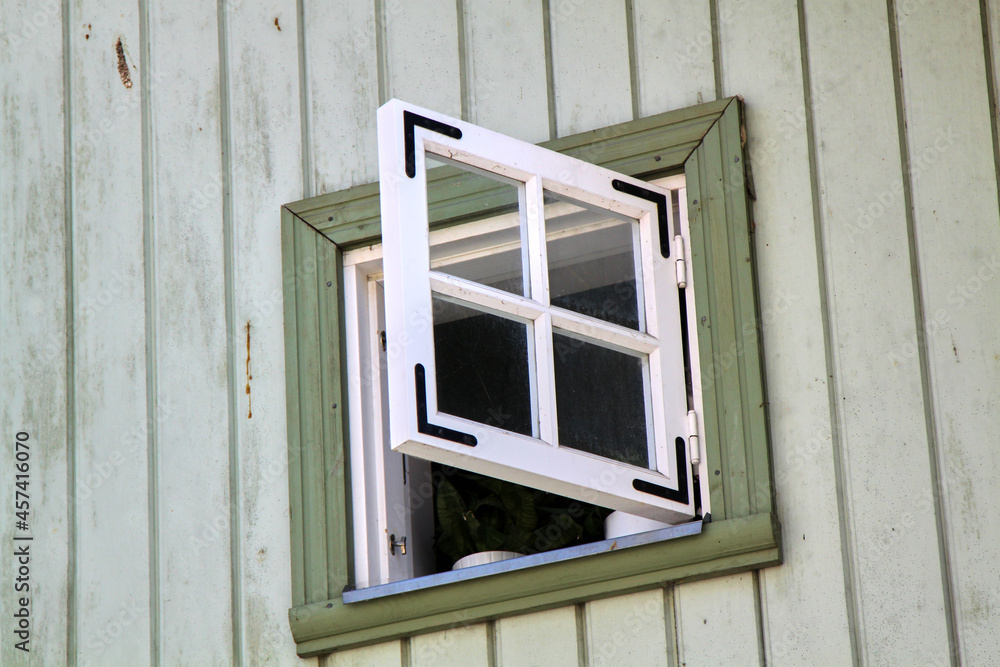 A square window of a green wooden house