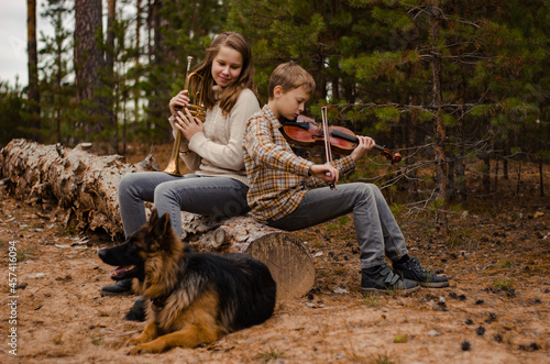Family duet brother and sister, boy and girl, teenagers play trumpet a