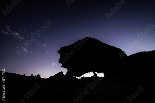 man sitting on a neolithic dolmen enjoying the sunset photo