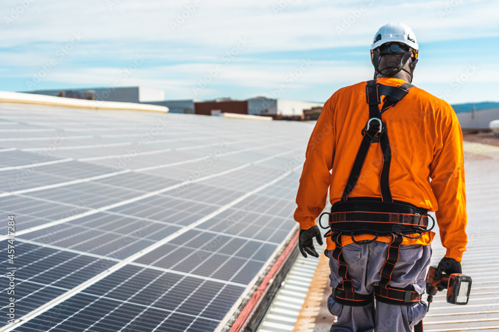 Unrecognizable solar panel technician walking in Spanish installation Unrecognizable solar panel technician walking in Spanish installation