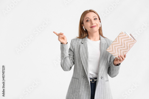 Mature woman with book poin...