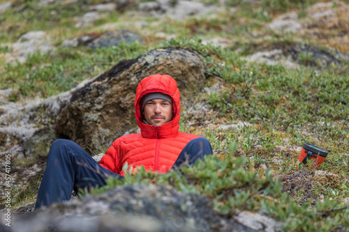 Portrait of a mountaineer wearing a red down jacket. photo