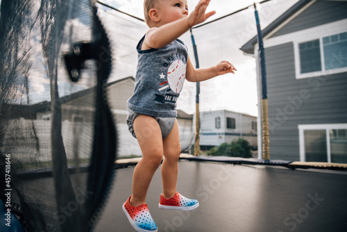 One year-old jumping on trampoline on 4th of July photo