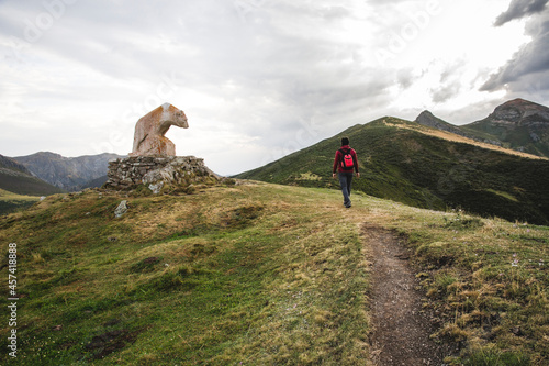 Man walking in the mountain next to bear statue Picos de Europa photo